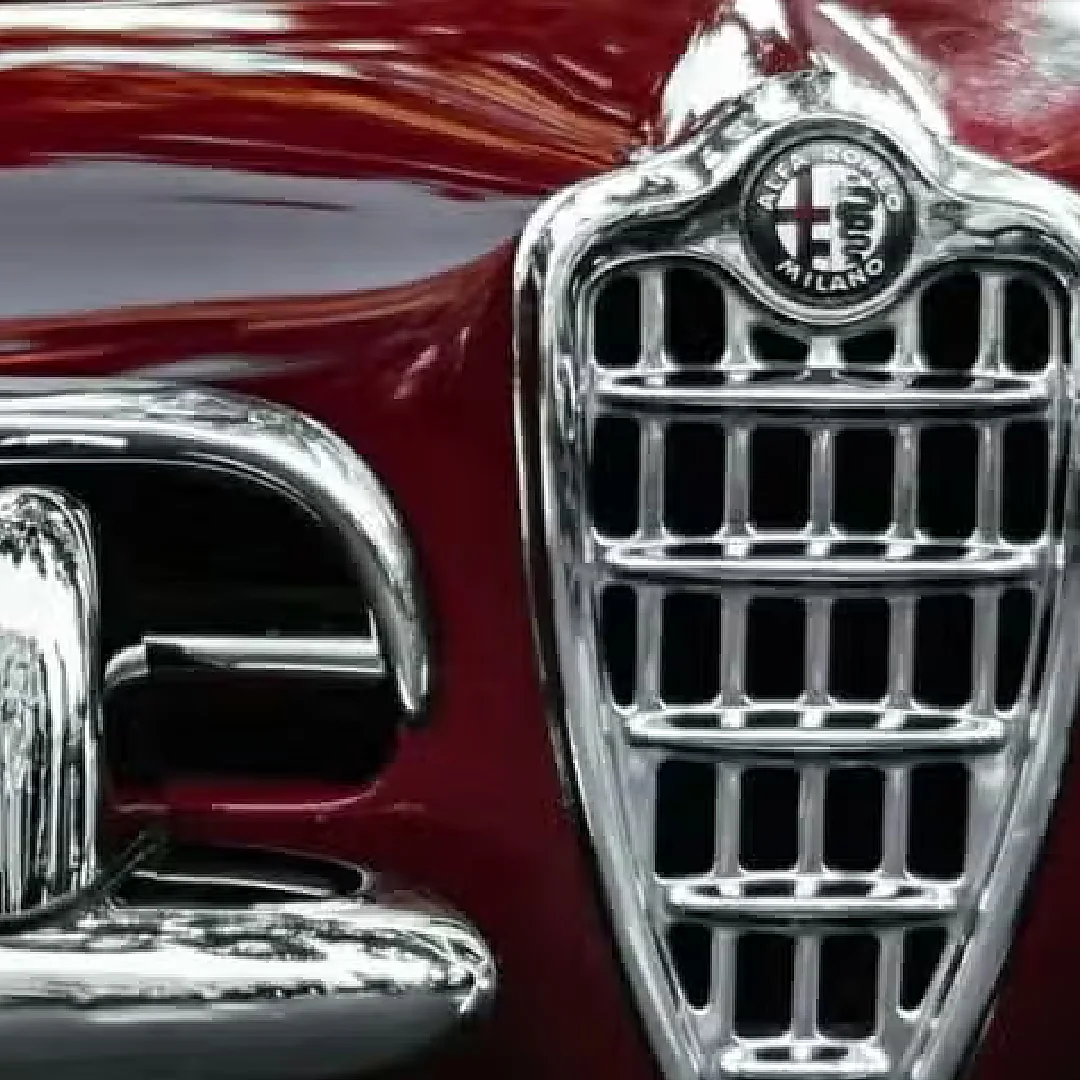 Dettaglio dello scudetto e della calandra cromata di un'Alfa Romeo Giulietta d'epoca rosso amaranto