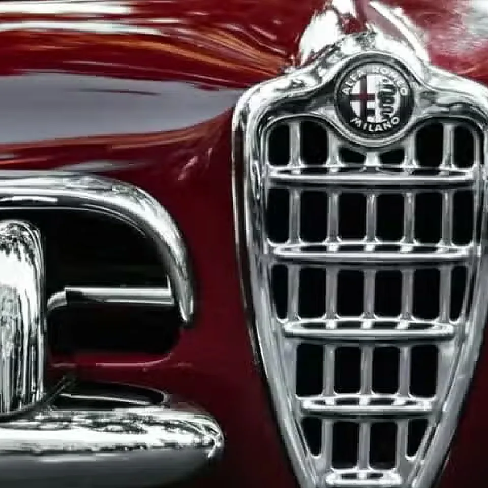 Dettaglio dello scudetto e della calandra di un'Alfa Romeo d'epoca rosso amaranto