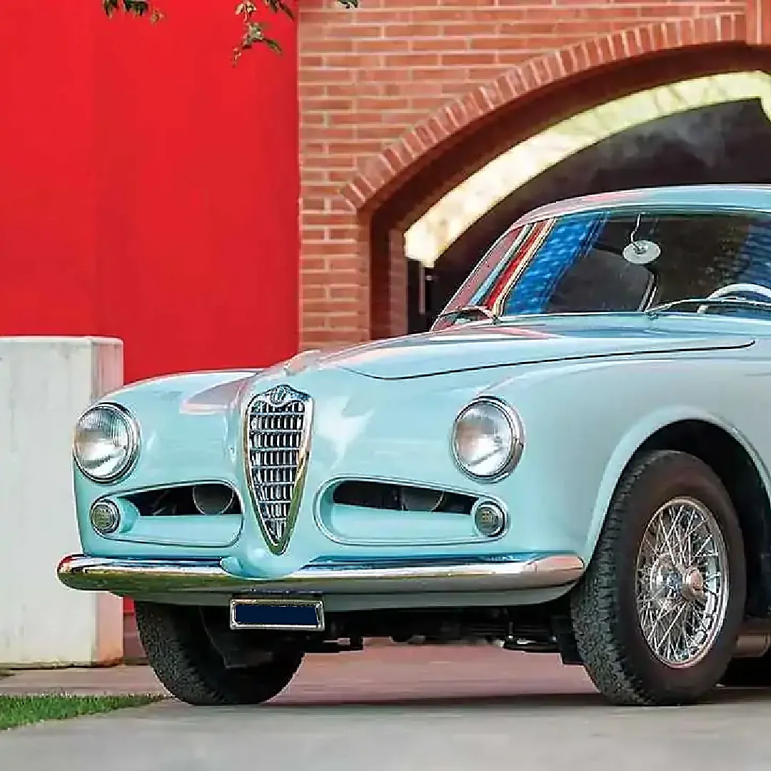 Alfa Romeo 1900 Sprint azzurra parcheggiata davanti a un arco in mattoni